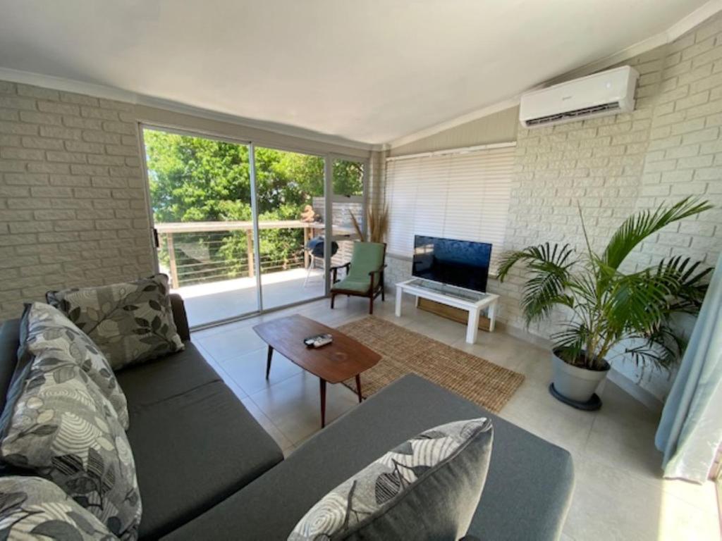 a living room with a couch and a table at Surf Motel in Umdloti