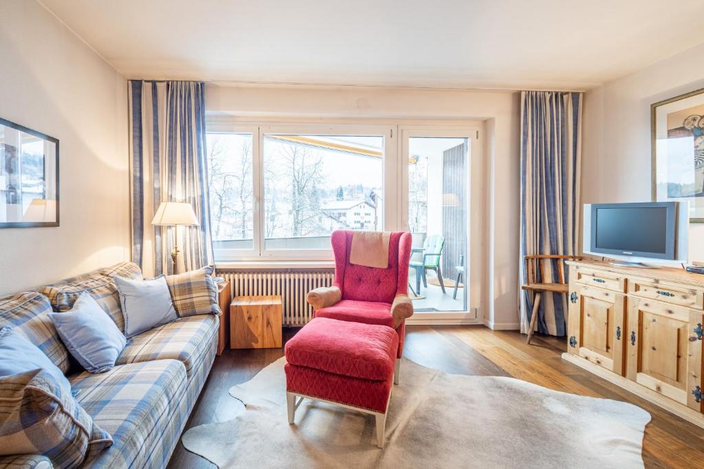 ein Wohnzimmer mit einem Sofa und einem TV in der Unterkunft Residenza Quadra B223 in Flims