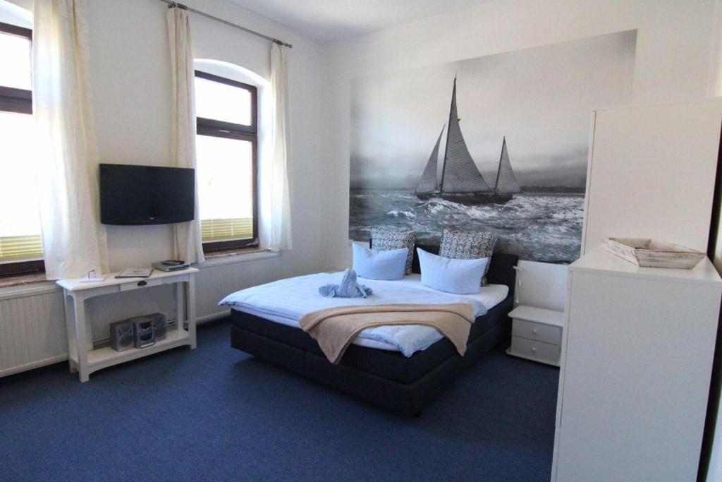 Kapitaenshaus-Lassen-Zimmer-Neptun في فيسترلاند: غرفة نوم بسرير ولوحة قارب شراعي