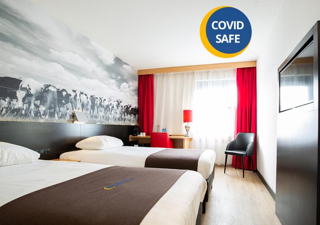 a hotel room with two beds and a sign that reads combsafe at Bastion Hotel Zoetermeer in Zoetermeer