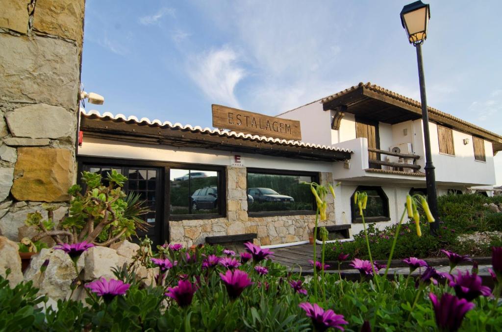 um edifício com flores roxas em frente em Estalagem Muchaxo Hotel em Cascais