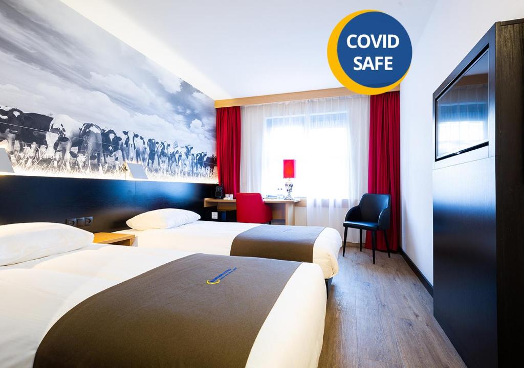 a hotel room with two beds and a sign that reads combsafe at Bastion Hotel Den Haag Rijswijk in Rijswijk