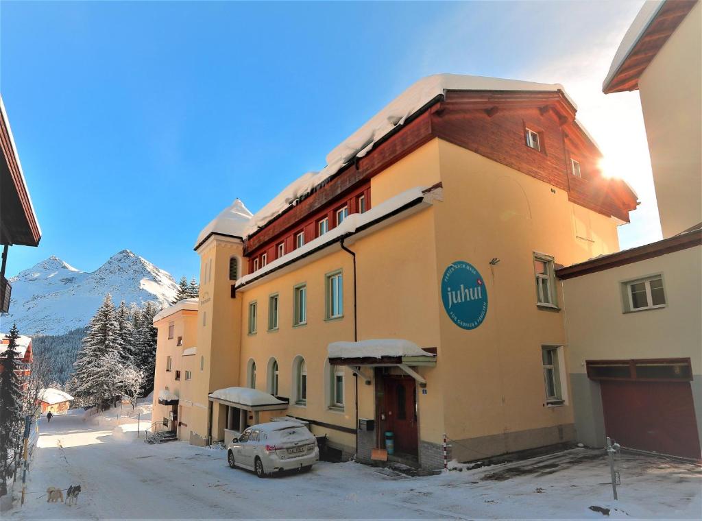 a building with a car parked in front of it at juhui Arosa in Arosa