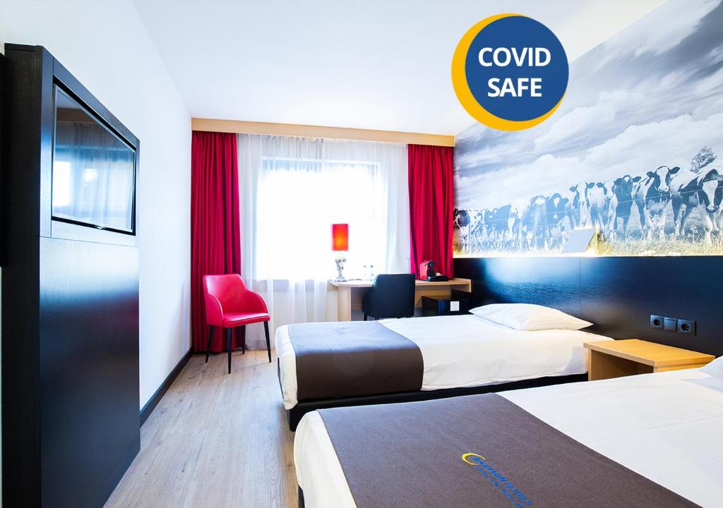 a hotel room with two beds and a sign that reads combsafe at Bastion Hotel Roosendaal in Roosendaal