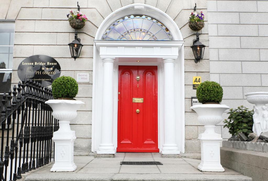 une porte rouge sur le côté du bâtiment dans l'établissement Leeson Bridge Guesthouse, à Dublin