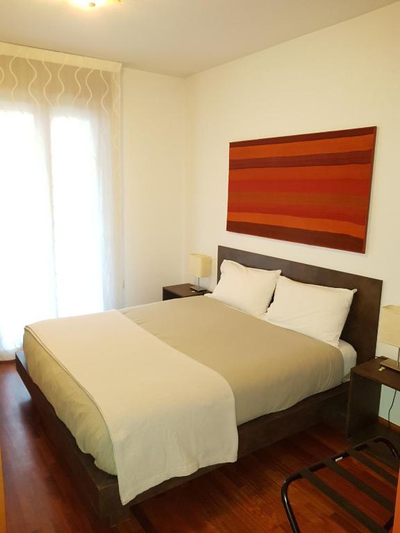 a bedroom with a large bed with white sheets at Guest House Marco Polo in Vicenza