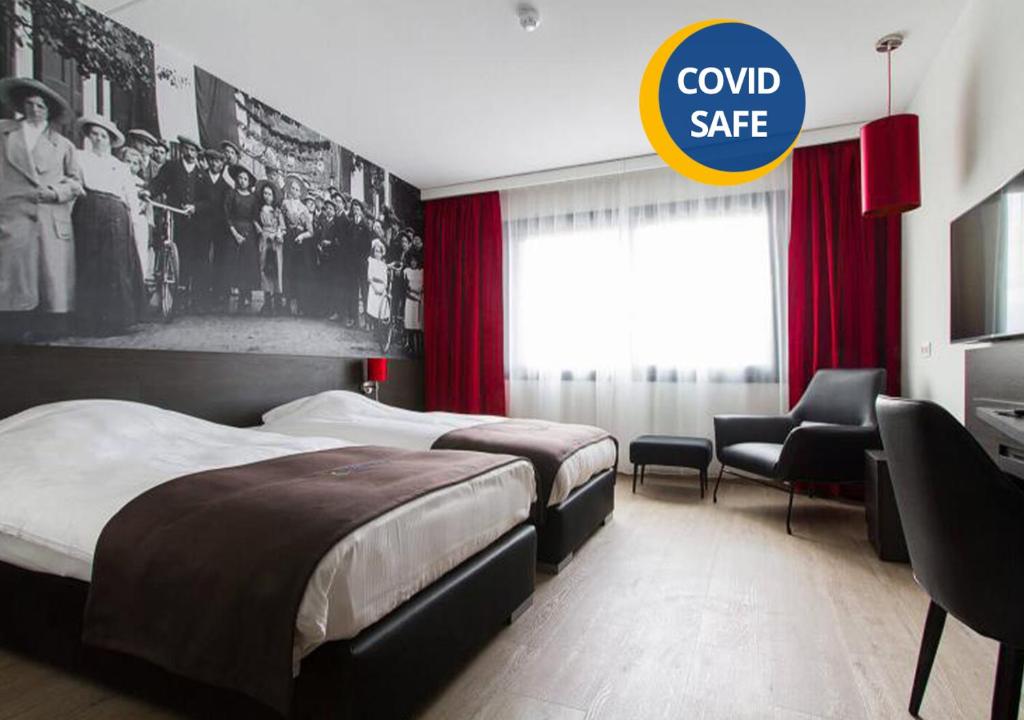 a hotel room with two beds and a sign that reads cold safe at Bastion Hotel Eindhoven Waalre in Eindhoven