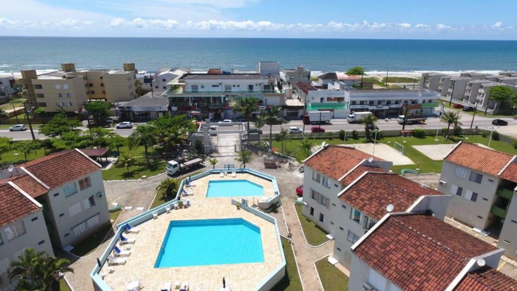 una vista aérea de un complejo con piscina y el océano en Brejatuba Residence! Conforto e lazer em excelente condomínio, en Guaratuba