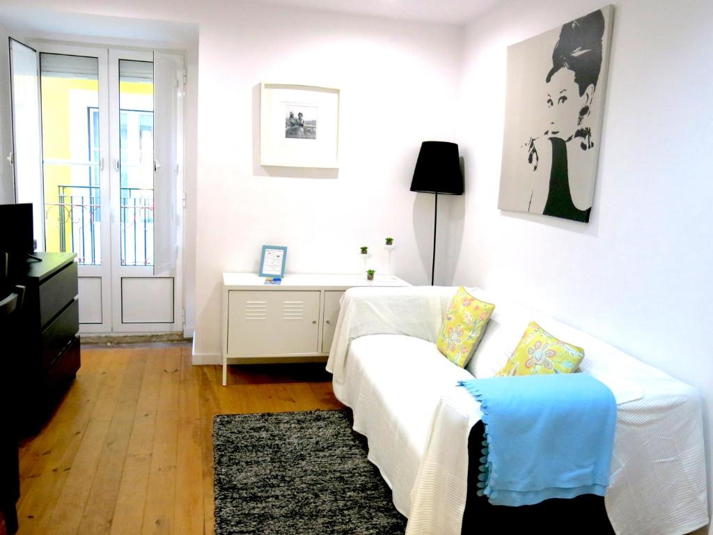 ein Wohnzimmer mit einem weißen Sofa und einem Tisch in der Unterkunft Wonderful Studio in Lisbon in Lissabon