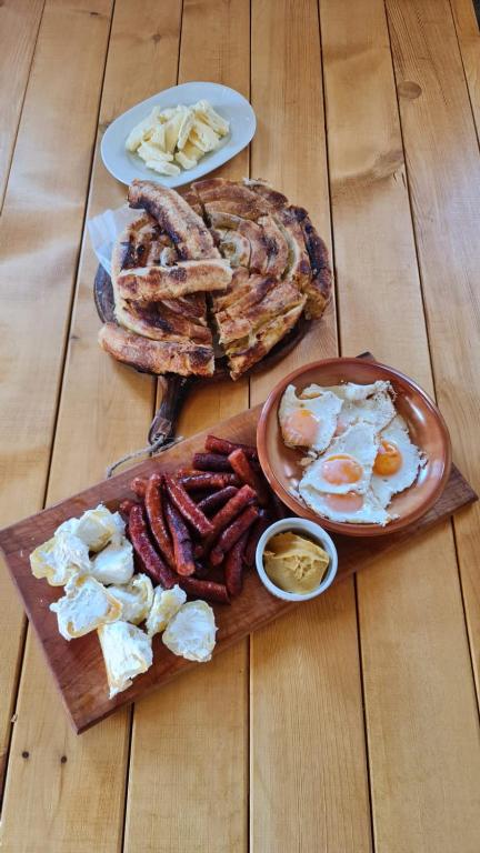 a table with a plate of breakfast food with eggs and bacon at ETNO SELO VRANEŠA Zlatar in Nova Varoš