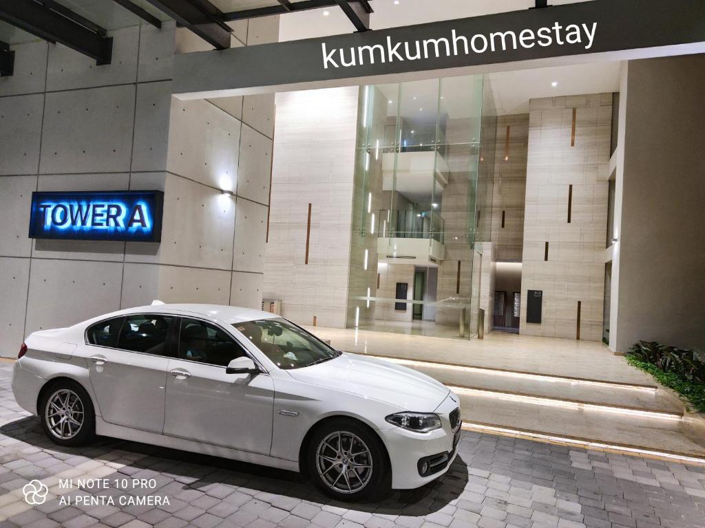 a white car parked in front of a building at Kumkum Homestay Studio in Nusajaya