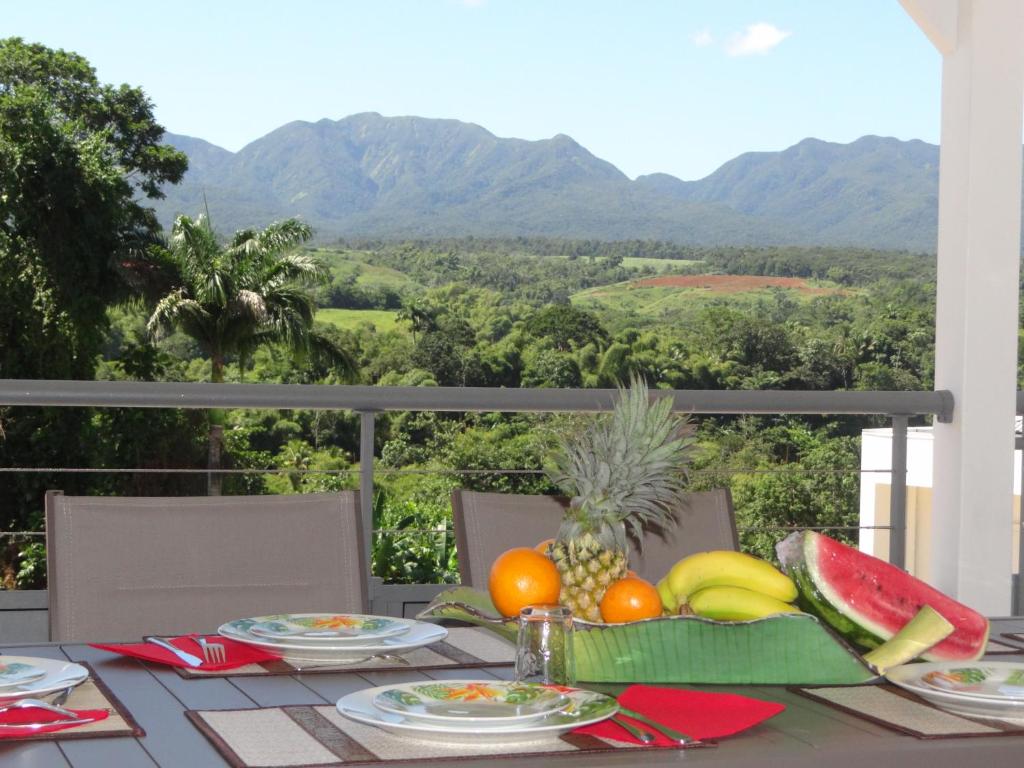 un tavolo con frutta e vista sulle montagne di Les Balcons du Parc a Petit-Bourg