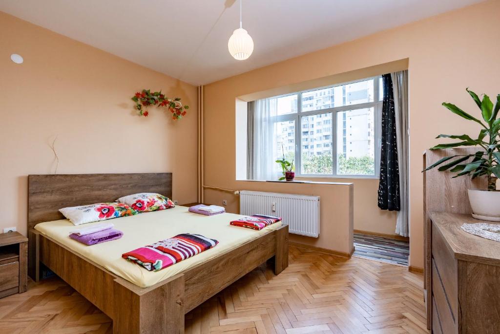 um quarto com uma cama com almofadas e uma janela em Апартаменти Уют em Plovdiv