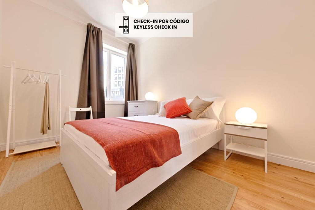a white bedroom with a bed and a window at Sleep in Centre in Porto