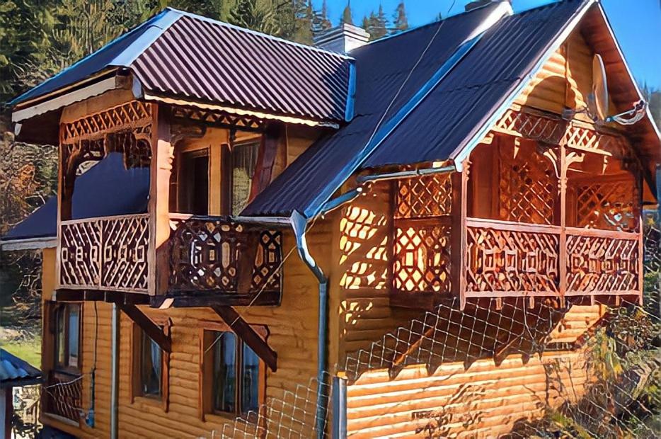 Cabaña de madera con porche y balcón en Karpaty Gutsulska Sadyba, en Mykulychyn