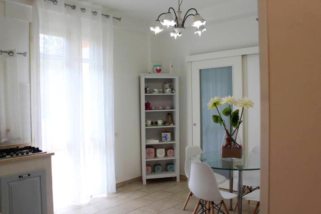 uma sala de jantar com uma mesa de vidro e cadeiras brancas em 2 bedrooms apartement at Marina di Modica 200 m away from the beach with furnished terrace and wifi em Marina di Modica