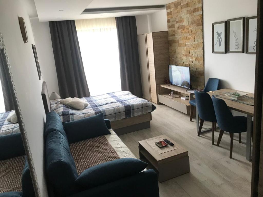 uma sala de estar com um sofá, uma cama e uma mesa em Milmari apartman SAN-28 em Kopaonik