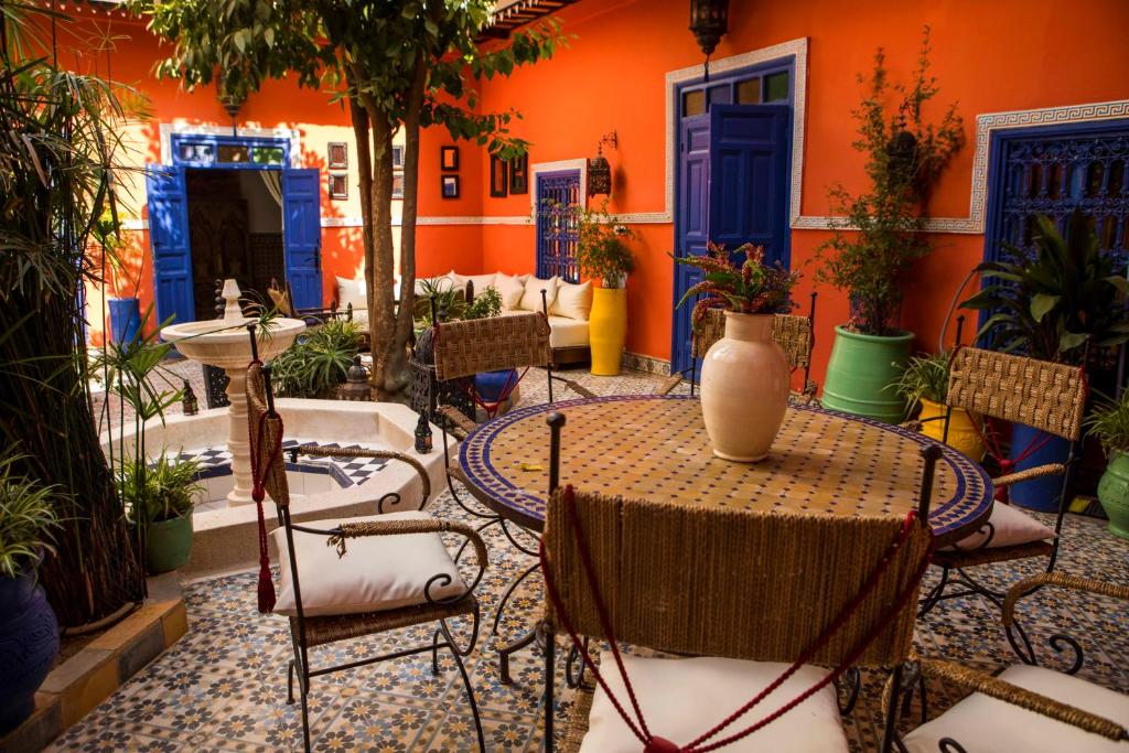 a patio with a table and chairs with a vase on it at Riad 7 Rijal Marrakech in Marrakesh