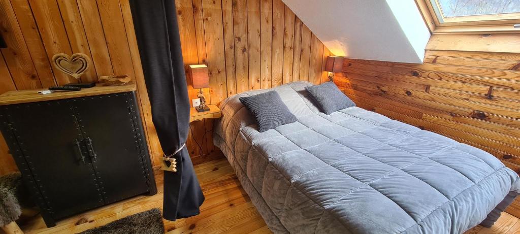 um quarto com uma cama num quarto com paredes de madeira em Chambre d'Hôtes Kiki & Coco em Saint-Jean-de-Maurienne