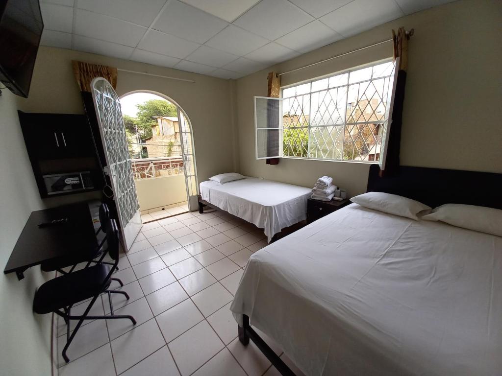 a bedroom with two beds and a window at Kira's House in Piura