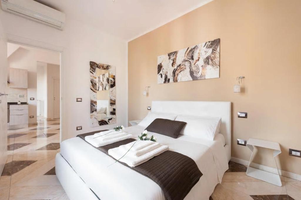 een witte slaapkamer met een wit bed en een stoel bij WiFi Superfast!Close to Statue of David! in Florence