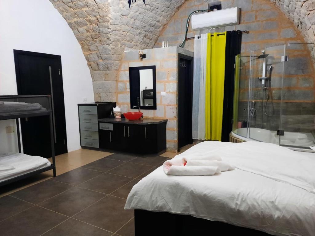 een badkamer met een bed, een douche en een wastafel bij Mandala in Mount מנדלה בחרמון סוויטה in Majdal Shams