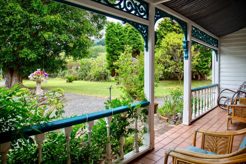 a porch with a view of a garden at Karamana Homestead (1872) in Coromandel Town