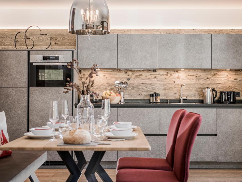una cucina con tavolo e sedie di LENZup Apartments a Mayrhofen