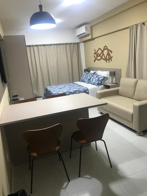 een kamer met een bureau, 2 stoelen en een bed bij Edificio Time Apto 625 in Maceió