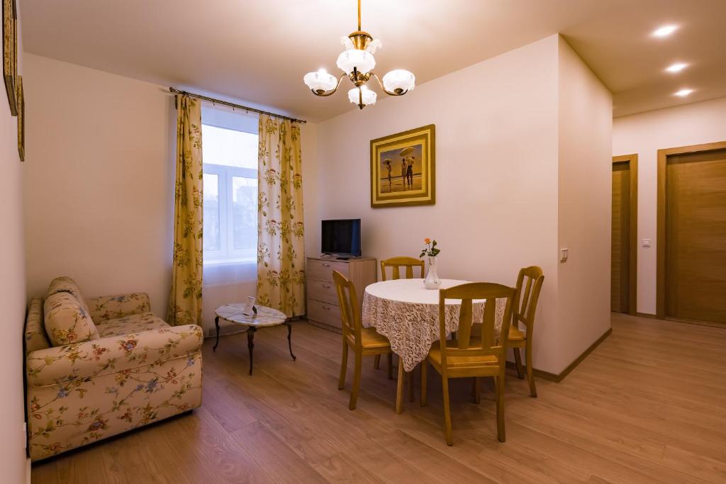 een woonkamer met een eettafel en een bank bij Allegro in Liepāja