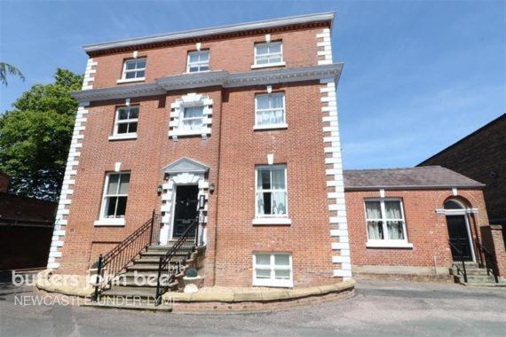a red brick building with stairs in front of it at Buckingham House Apartment 2 in Macclesfield