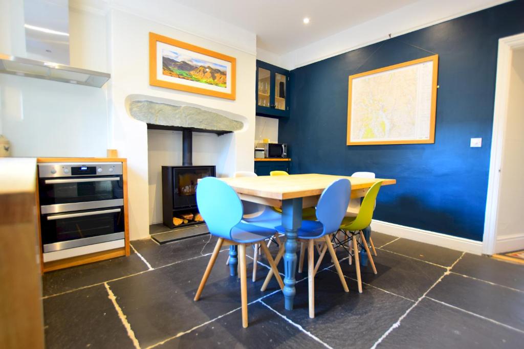 a kitchen with a table and chairs and a fireplace at Holmdale, Ambleside in Ambleside