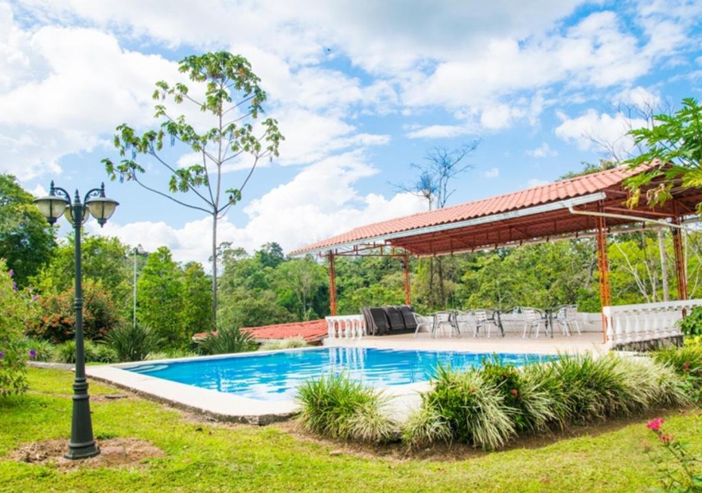 uma piscina num quintal com um pavilhão em Villas Josipek em La Fortuna