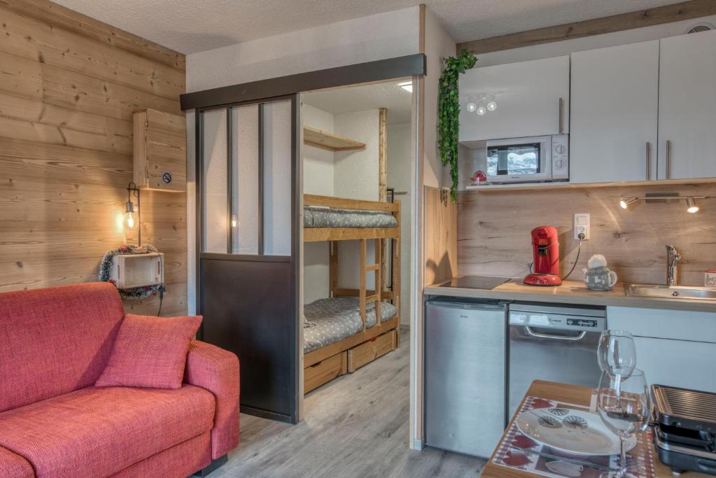 uma sala de estar com um sofá e uma cozinha com um beliche em Studio Cosy coin-nuit proche centre - Vue splendide em Saint-Gervais-les-Bains