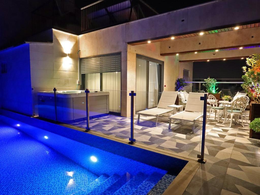 a house with a swimming pool and a patio at Luxury Rooftop Apartment in Netanya in Netanya