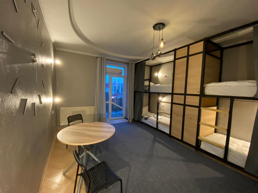 Pokój ze stołem i łóżkami piętrowymi w obiekcie Ehostel360 w Iwano-Frankiwsku