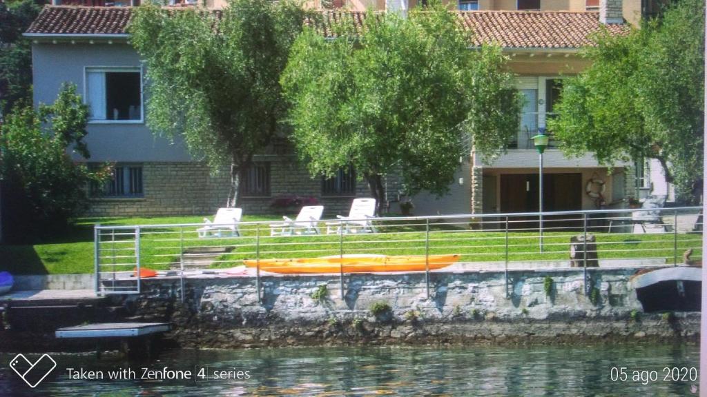 dom z krzesłami i łódź w wodzie w obiekcie Freddy Holiday House w mieście Predore