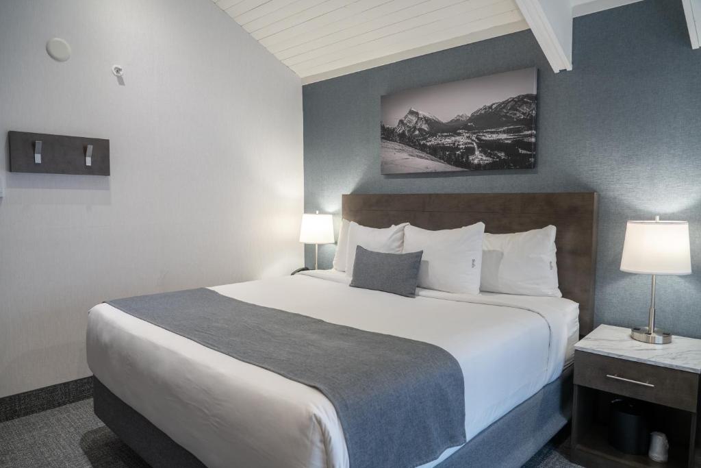 Habitación de hotel con 1 cama grande y 2 lámparas en Red Carpet Inn en Banff
