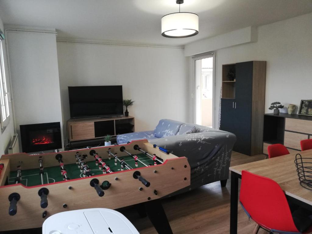 una sala de estar con una mesa de ajedrez grande en Grand T3 avec clim, parking et terrasse privative - Agen, en Agen