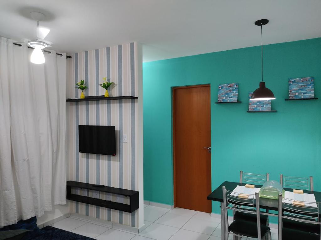 una sala da pranzo con tavolo e TV di Apartamento Space Calhau a São Luís
