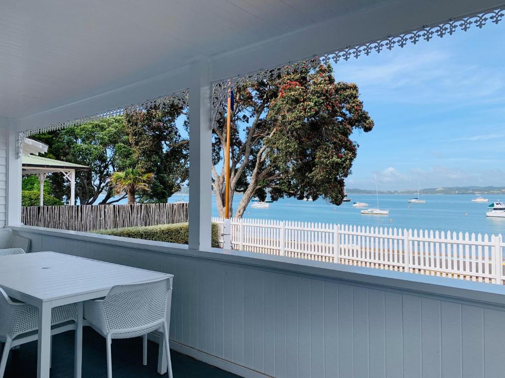 a porch with a table and chairs and a view of the water at 9 The Strand in Russell