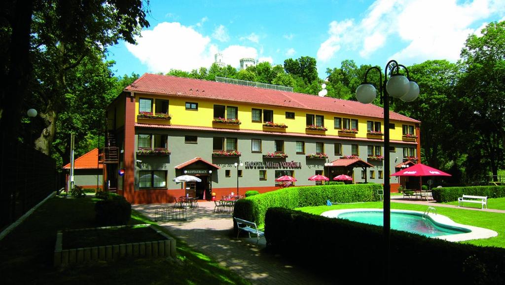 a large building with a pool in front of it at Hotel Milan Vopicka in Hluboká nad Vltavou