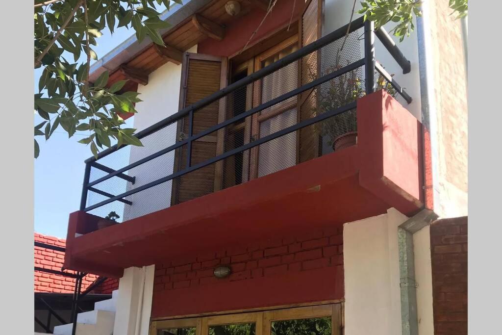 un balcón rojo en el lateral de un edificio en Departamento ALUMA, en San Rafael