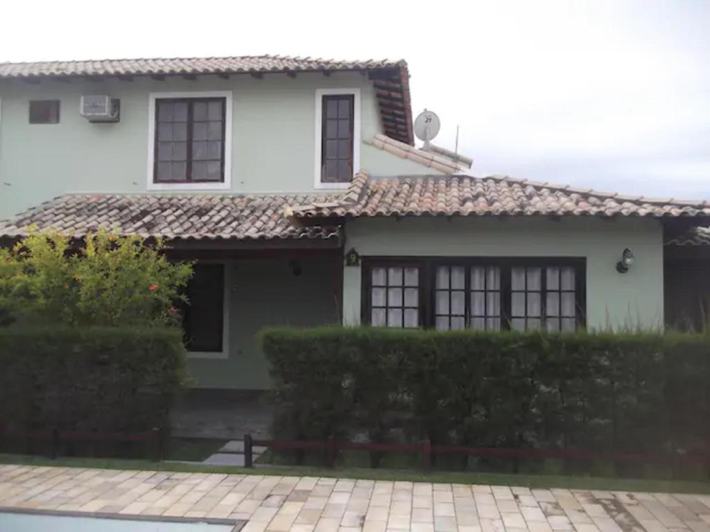 uma casa branca com telhado de azulejo em Linda casa para temporada no Peró/Cabo Frio em Cabo Frio
