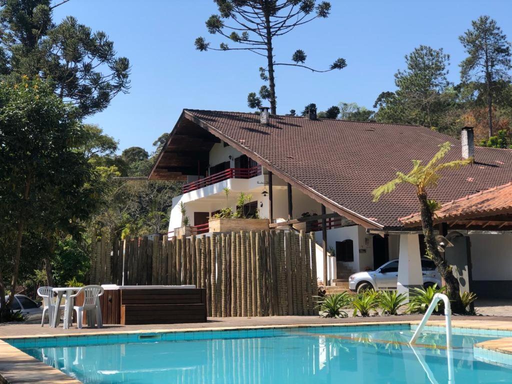 a house with a swimming pool in front of a house at Hotel Casa Alpina in Núcleo Mauá