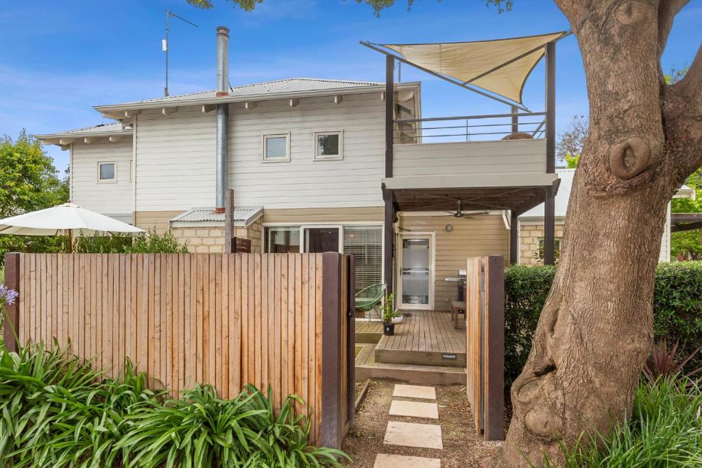 a house with a fence and trees at Seahaven Village in Barwon Heads