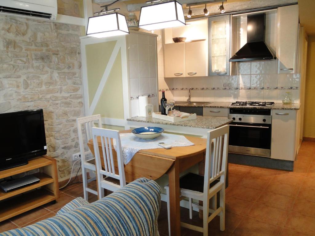 uma cozinha com uma mesa e um fogão forno superior em Cal Josep em Portell