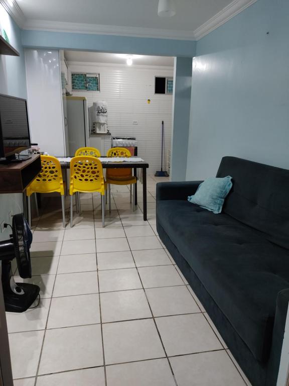 a living room with a couch and a table and chairs at Condomínio manguezal, Apartamento 07 in Porto De Galinhas