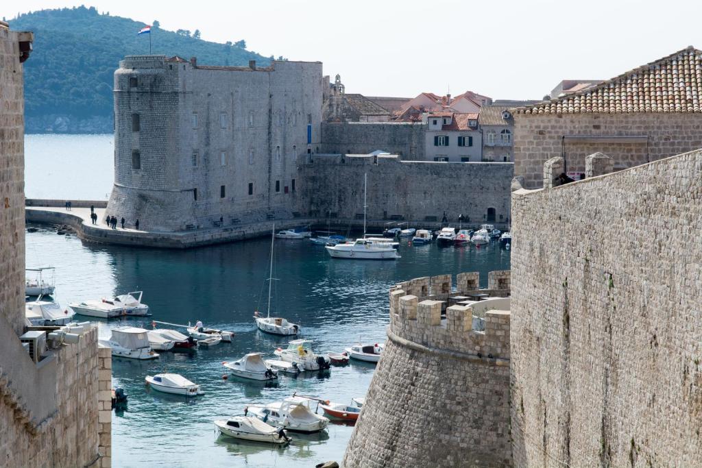 a group of boats in a harbor next to a castle at Apartment Ana in Dubrovnik