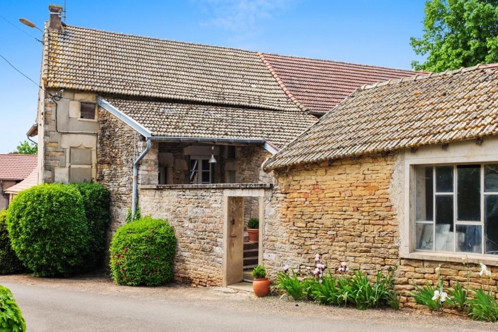 una antigua casa de piedra con ventana en Maison de 2 chambres avec jardin clos a Grevilly en Grevilly